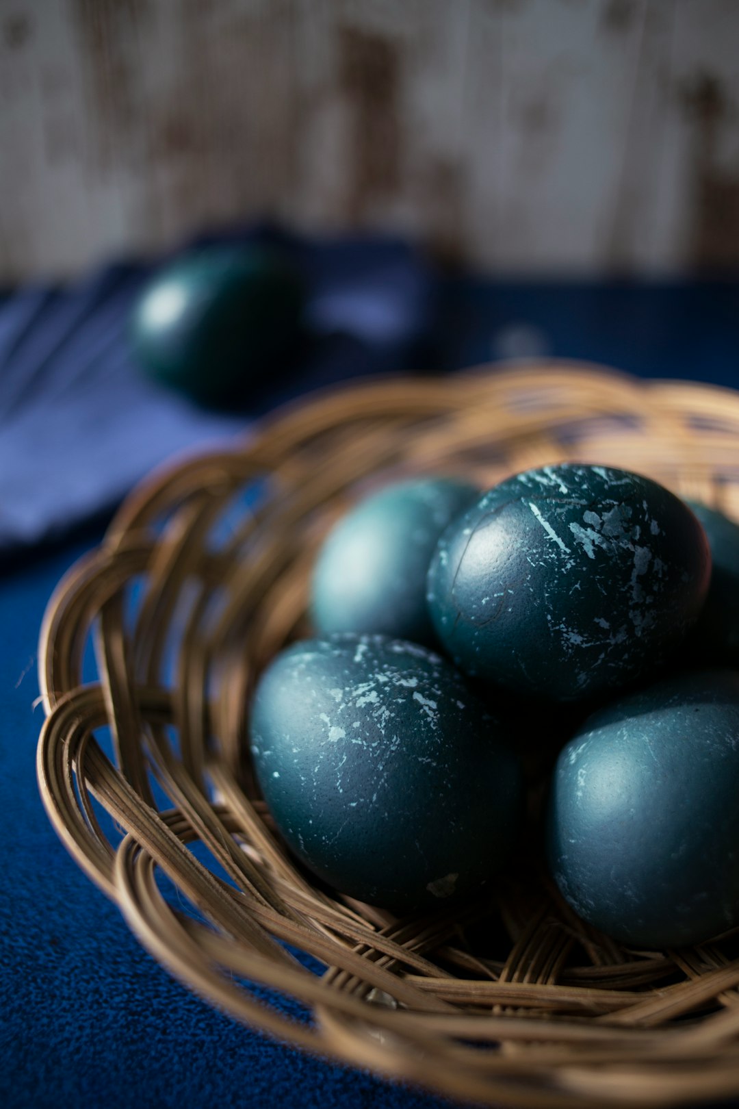 blue egg on brown woven basket