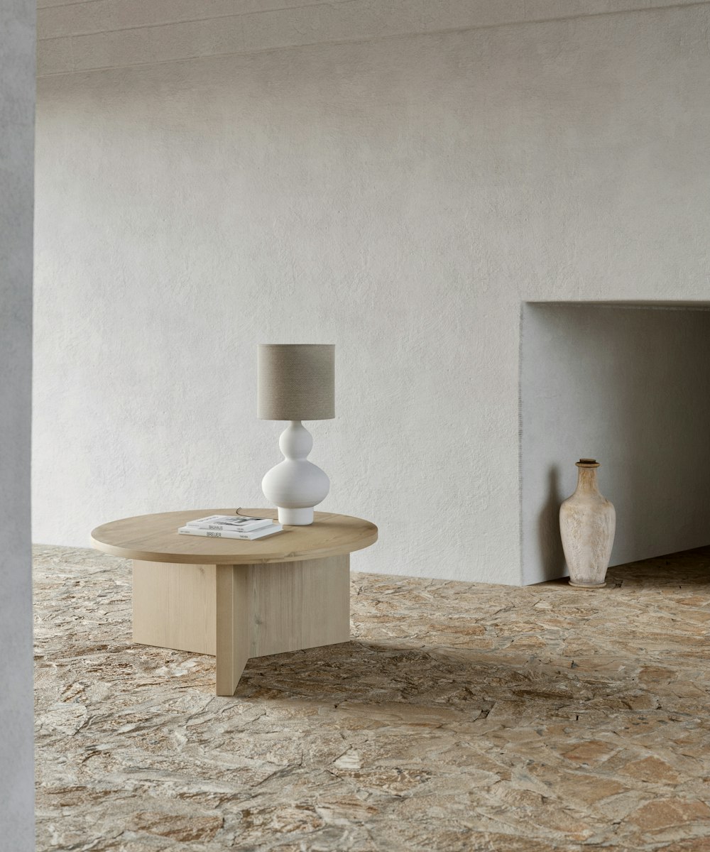 brown wooden table with white ceramic vase on top