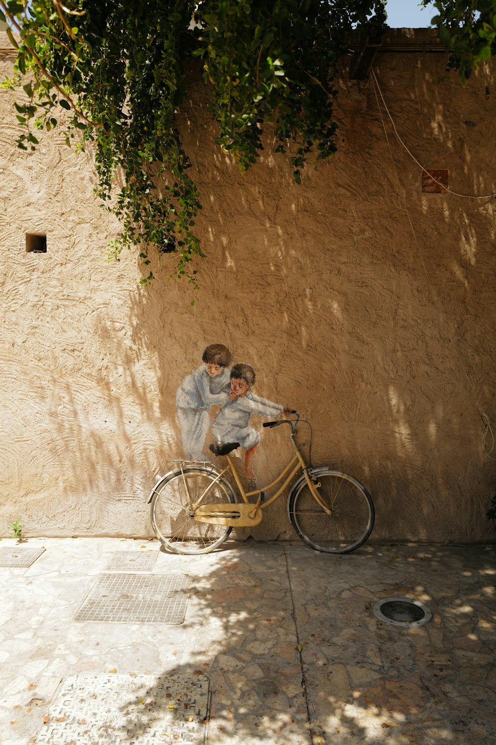 man and woman riding on bicycle beside brown concrete wall during daytime