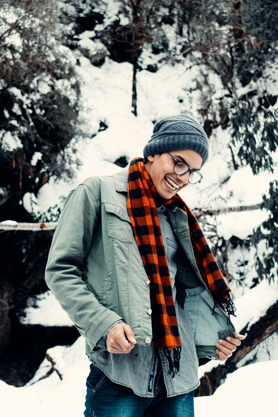 woman in gray jacket and gray knit cap standing on snow covered ground during daytime