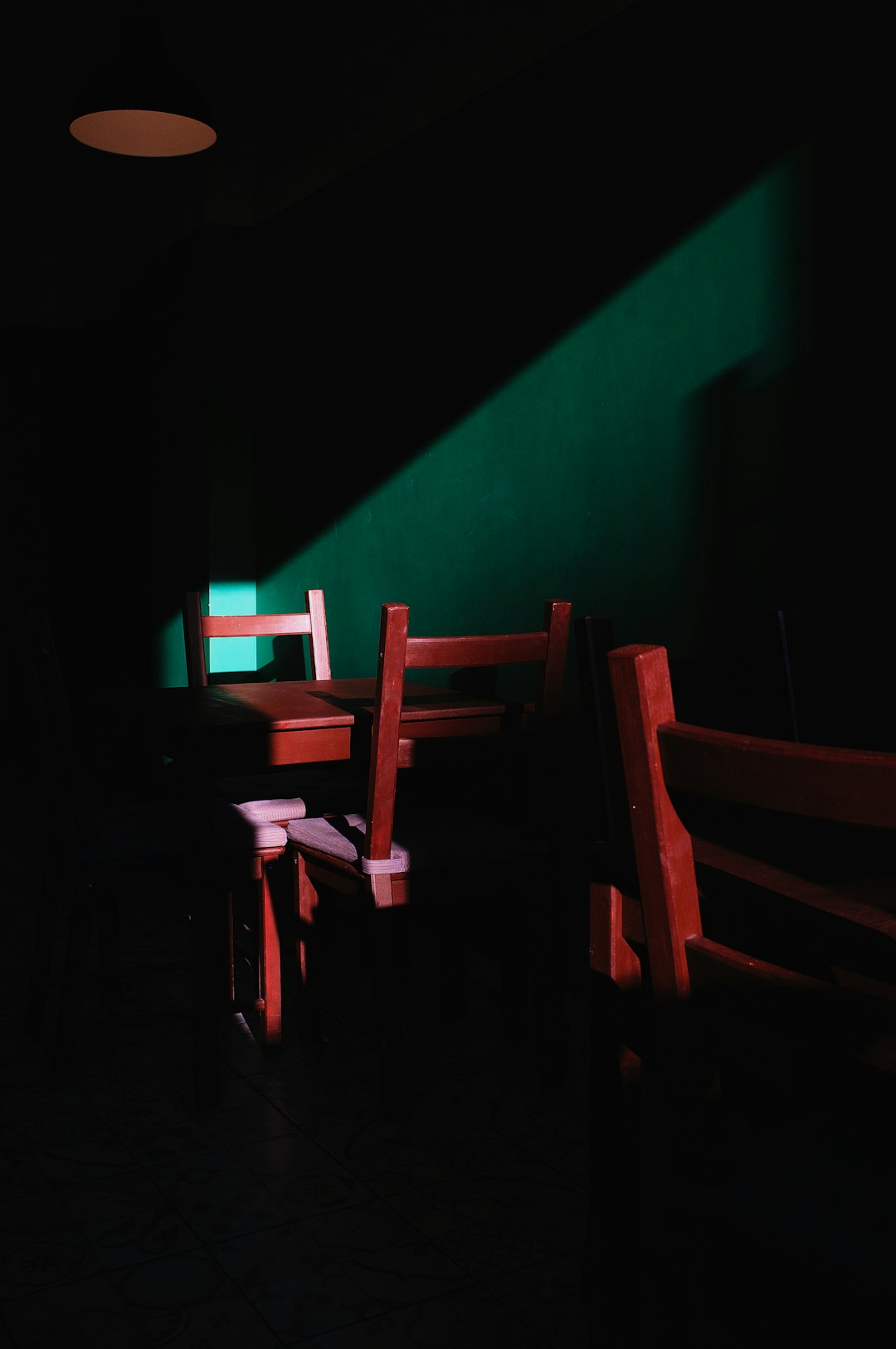 brown wooden chairs beside green wall