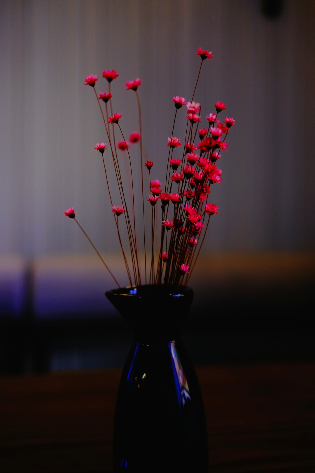red and white flower on blue glass vase