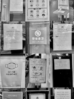 A collage of various signs and posters related to COVID-19 safety measures, displayed in what appears to be a public space. The signs include instructions for mask-wearing, social distancing, sanitation, and operational notices for businesses. Several signs also emphasize cleanliness and safety in environments like coffee shops, with images of masks, hand washing, and social distancing icons.