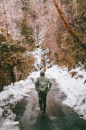 person in green jacket standing on snow covered ground