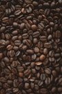 brown coffee beans on black surface