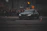 Close-up shot of a sleek R34 GTR drifting sharply on a wet urban street at night.