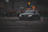Close-up shot of a sleek R34 GTR drifting sharply on a wet urban street at night.