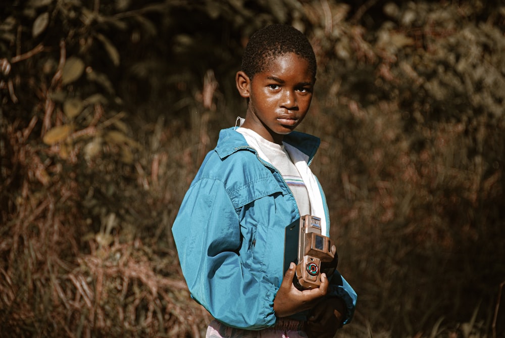 boy in blue dress shirt holding black dslr camera