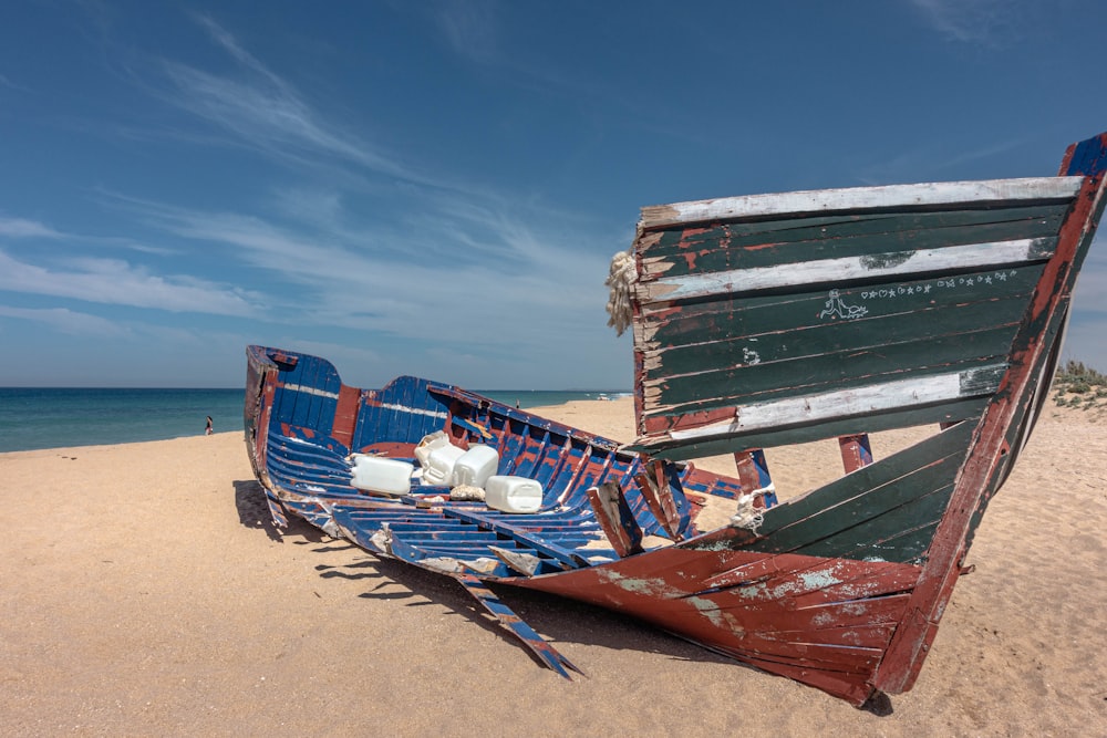 blue and red boat on beach during daytime