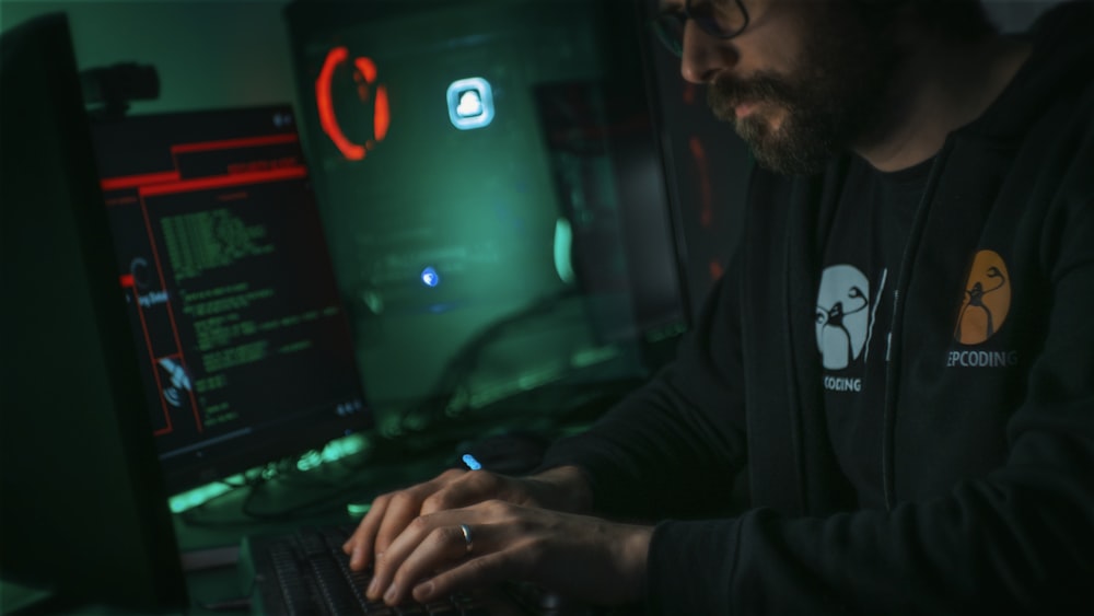 Mann in schwarzer Jacke mit Computer