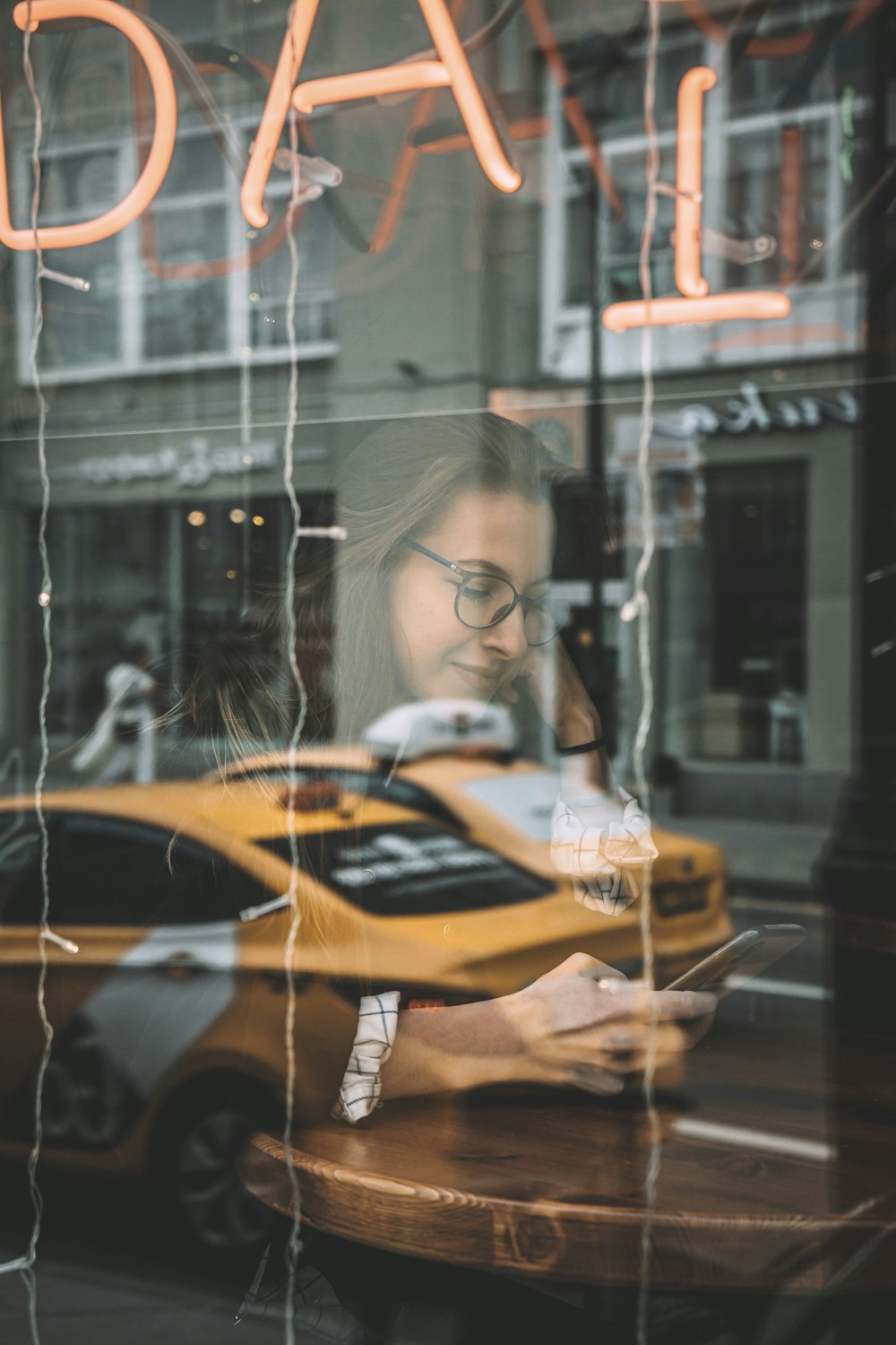 woman in black framed eyeglasses holding yellow and black car toy