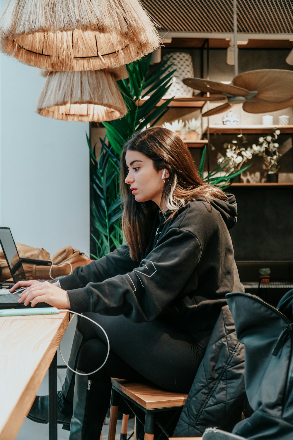 woman in black leather jacket sitting on black chair