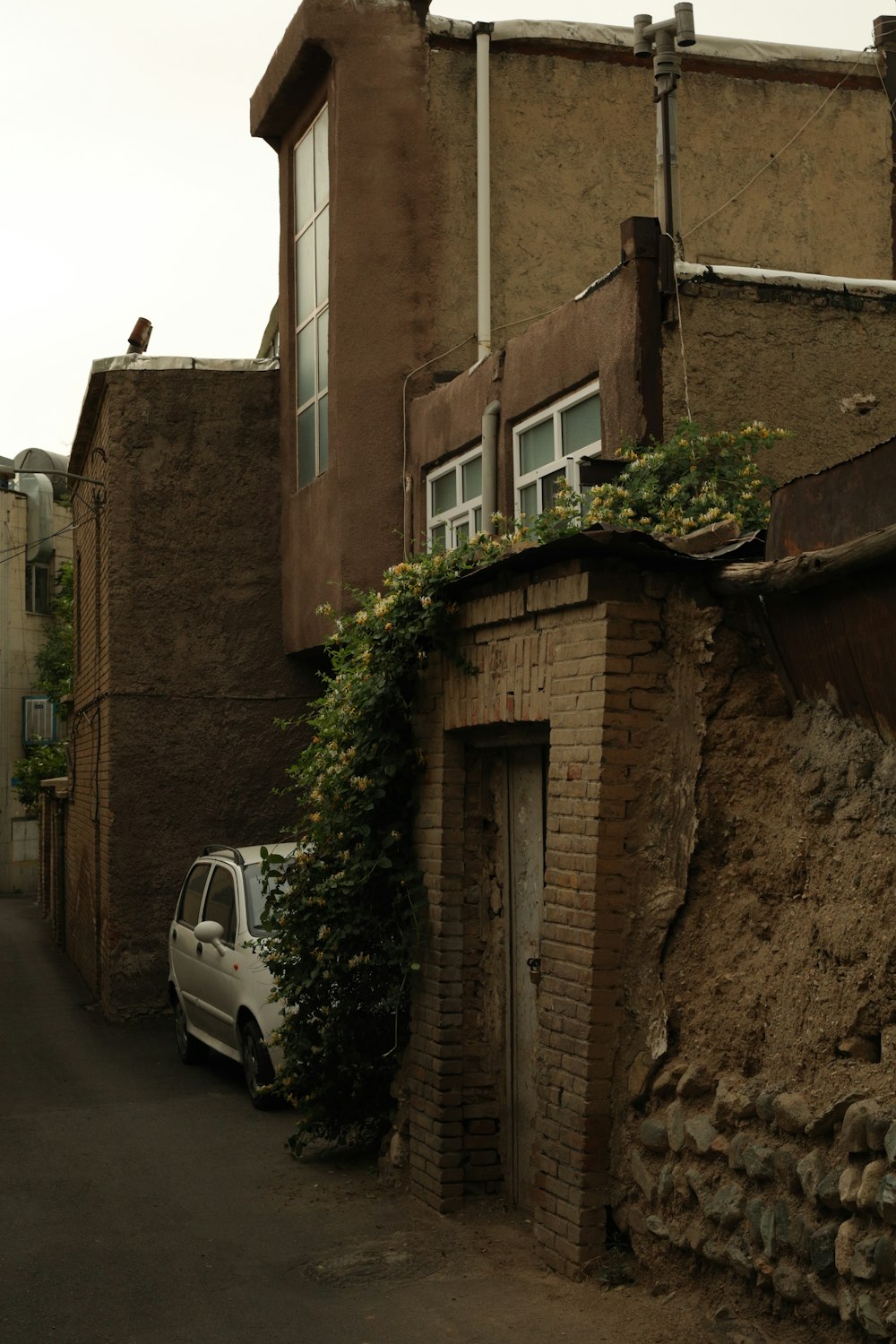 white car parked beside brown concrete building during daytime