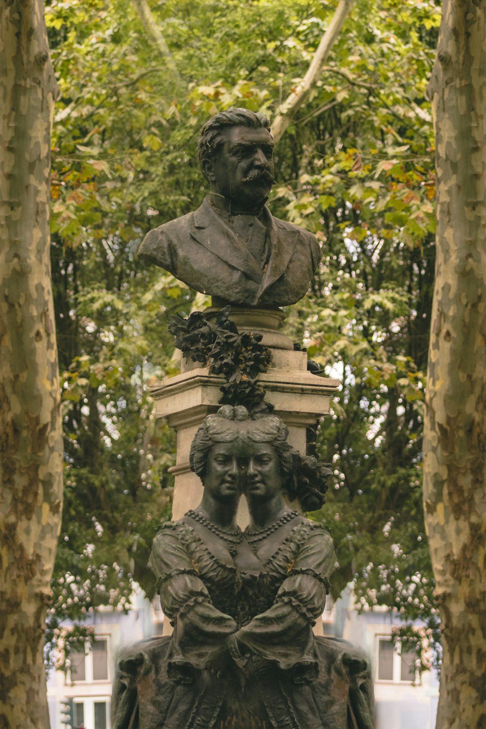 gray concrete statue near green trees during daytime