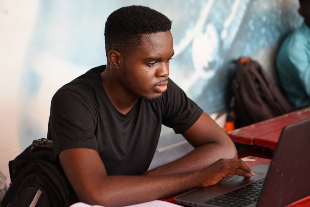 man in gray crew neck t-shirt using laptop computer