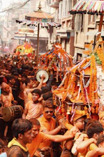 A lively street scene in Kashi with musicians and dancers celebrating a local festival.