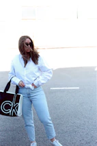 A happy customer carrying a full vėjas laundry bag through a sunny park.