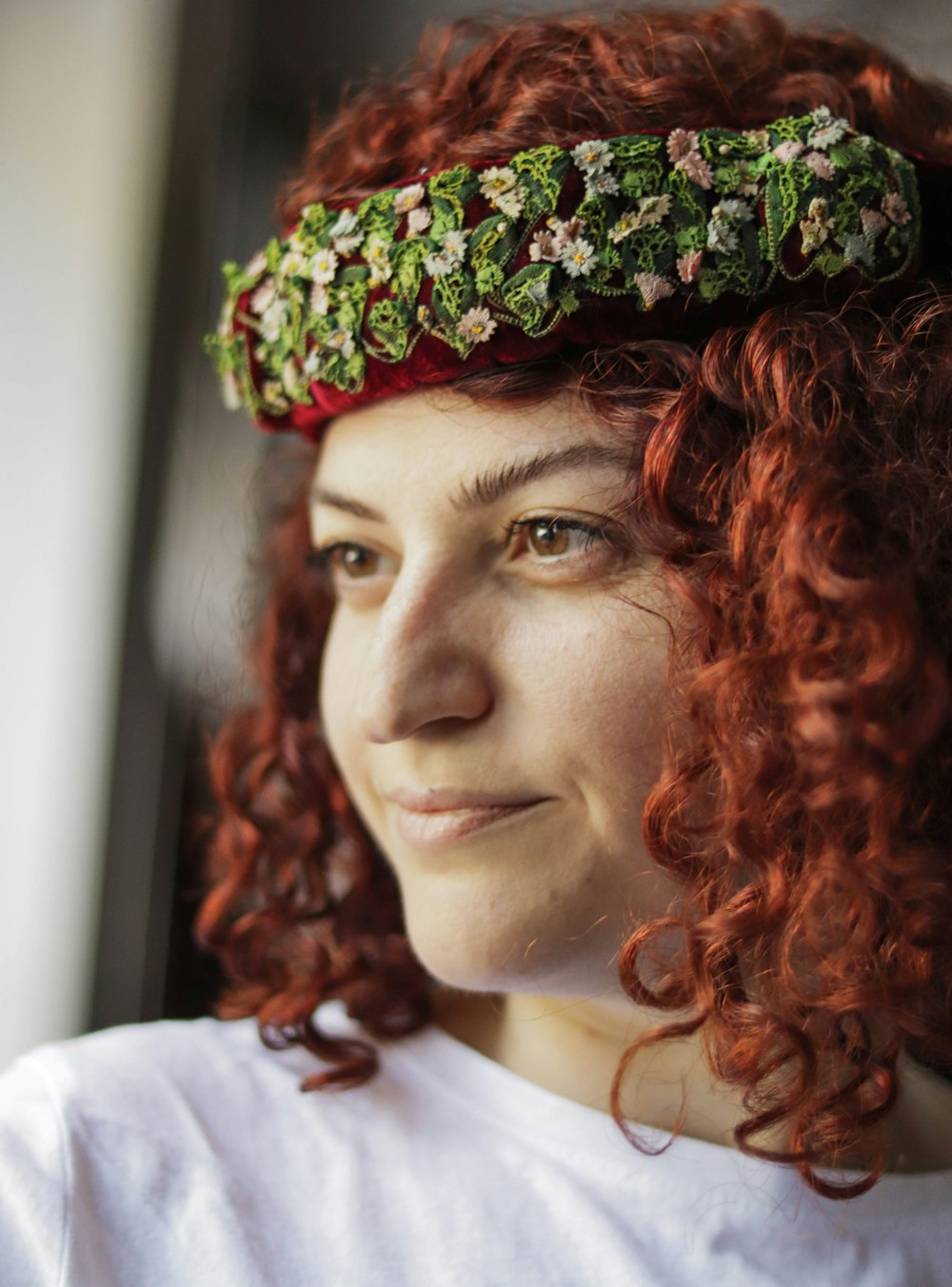 woman in white shirt wearing green and brown floral headdress