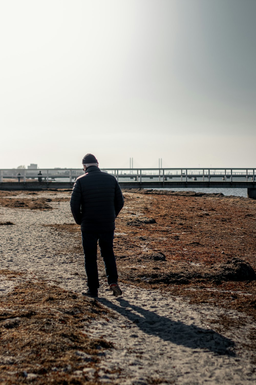 man in black jacket standing on brown field during daytime