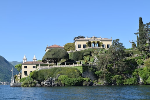 white and brown concrete building near body of water during daytime