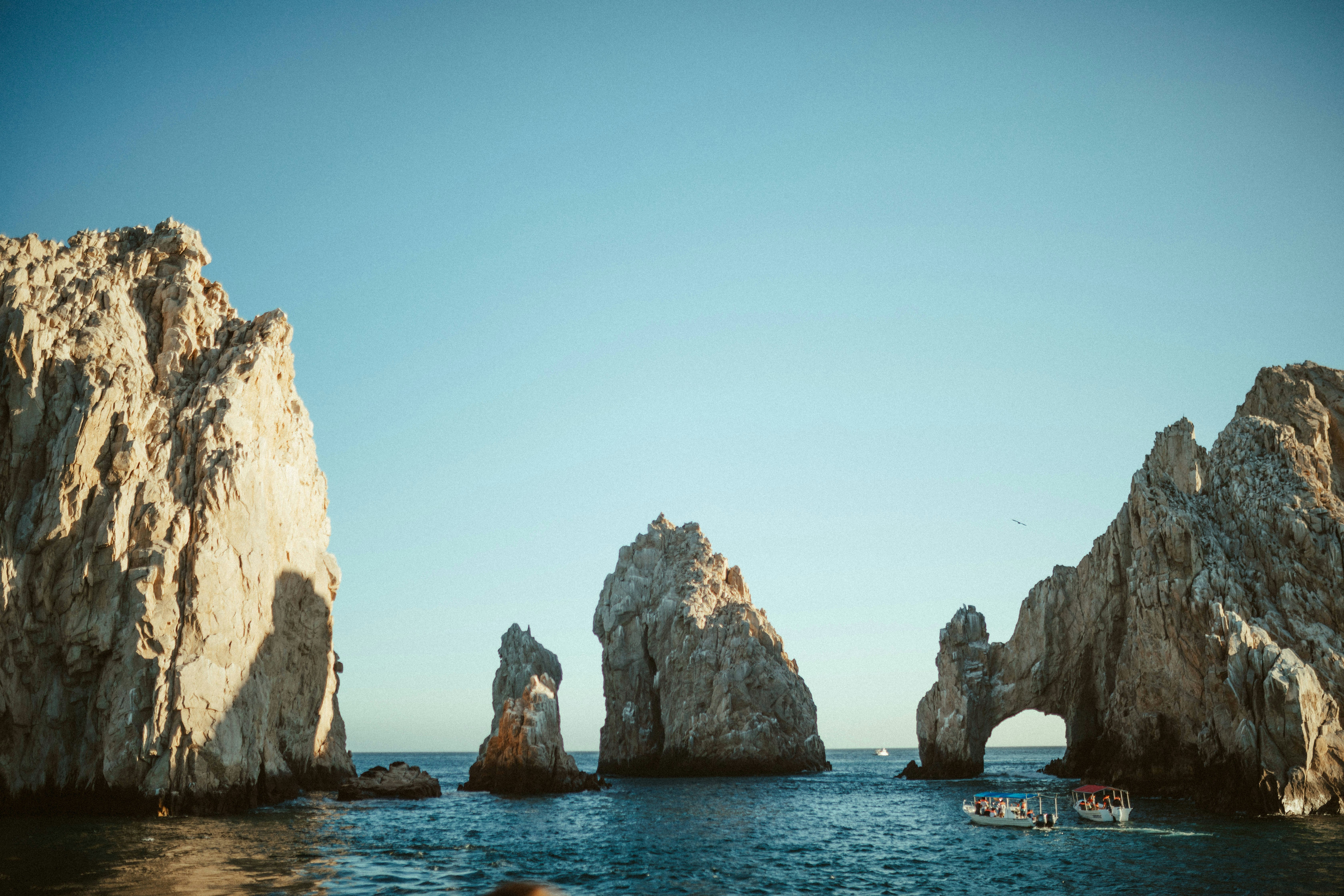 brown rock formation on blue sea under blue sky during daytime