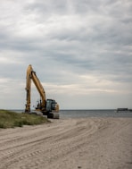 yellow and black heavy equipment on beach during daytime