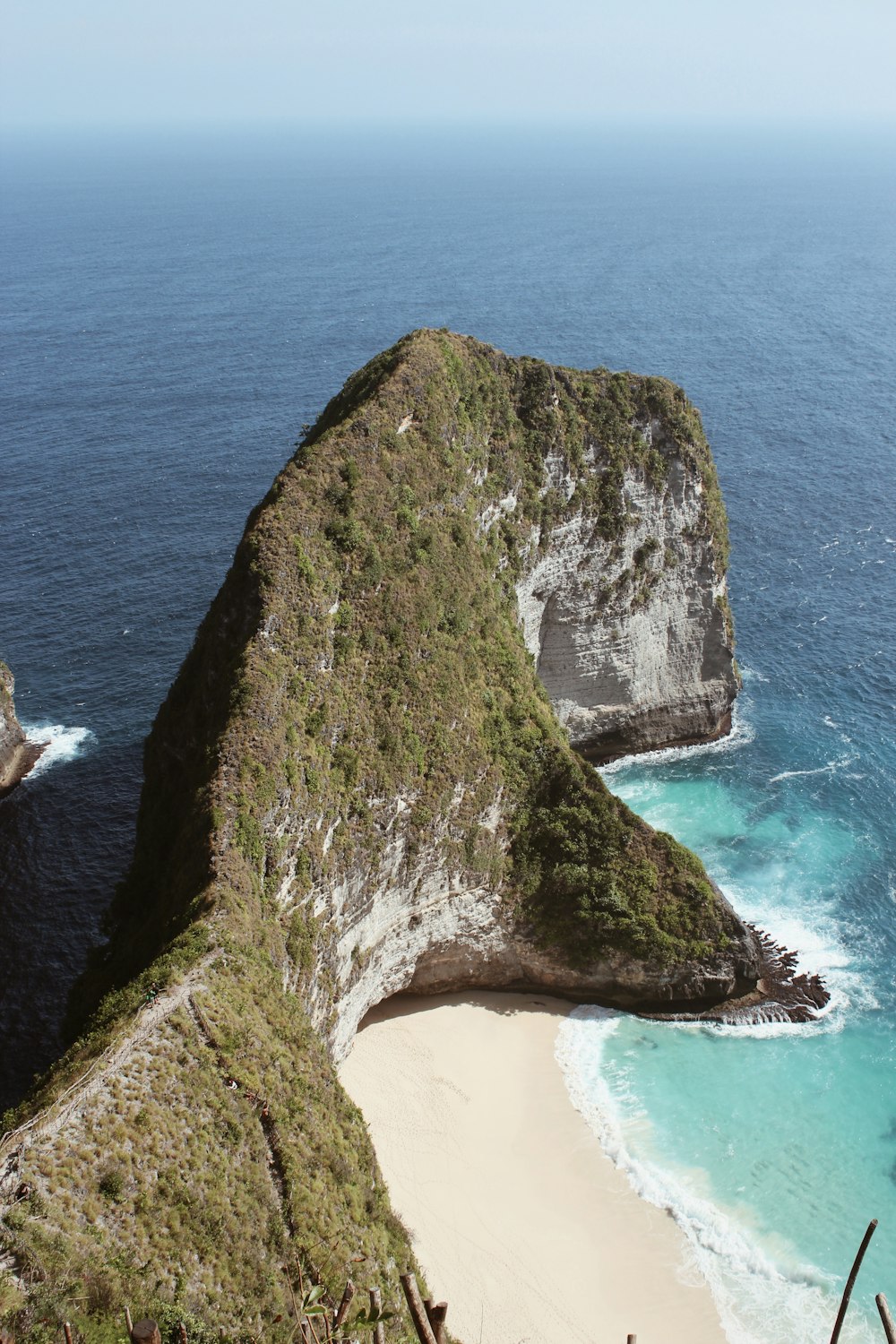 green and brown rock formation on beach during daytime