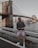 man in black jacket and pink shorts standing on gray concrete bridge during daytime