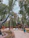 Children laughing and playing among colorful dinosaur statues in an immersive themed park.