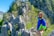 man in blue and yellow long sleeve shirt standing on gray rock during daytime