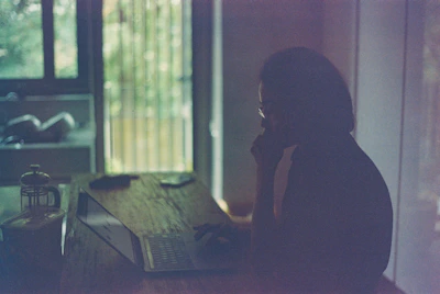 Portrait of a thoughtful blogger writing AI insights in a modern, bright room.