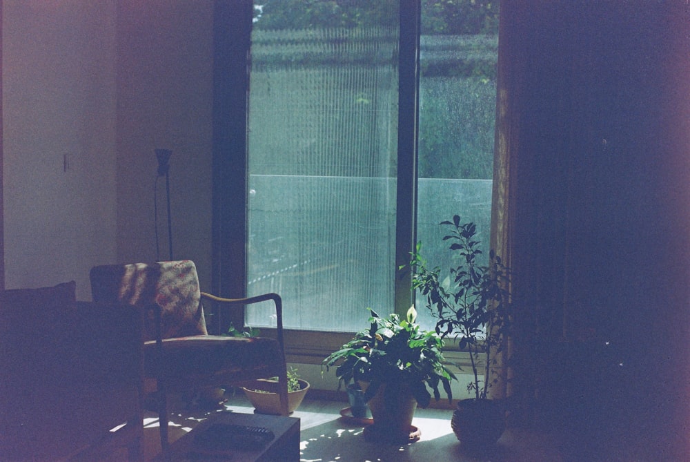 brown wooden armchair beside glass window