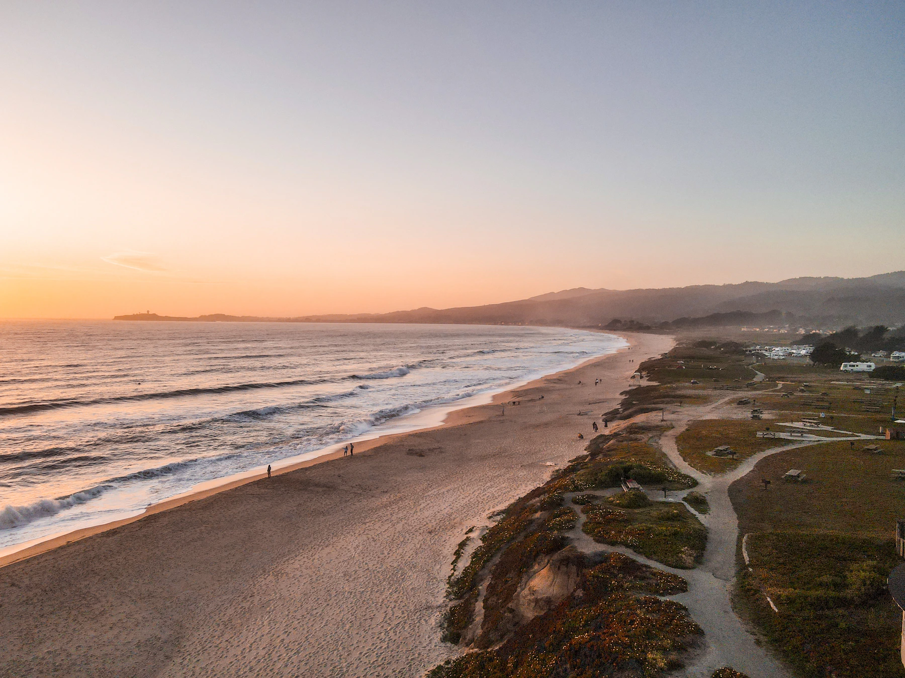 Lang strand i Half Moon Bay ved solnedgang