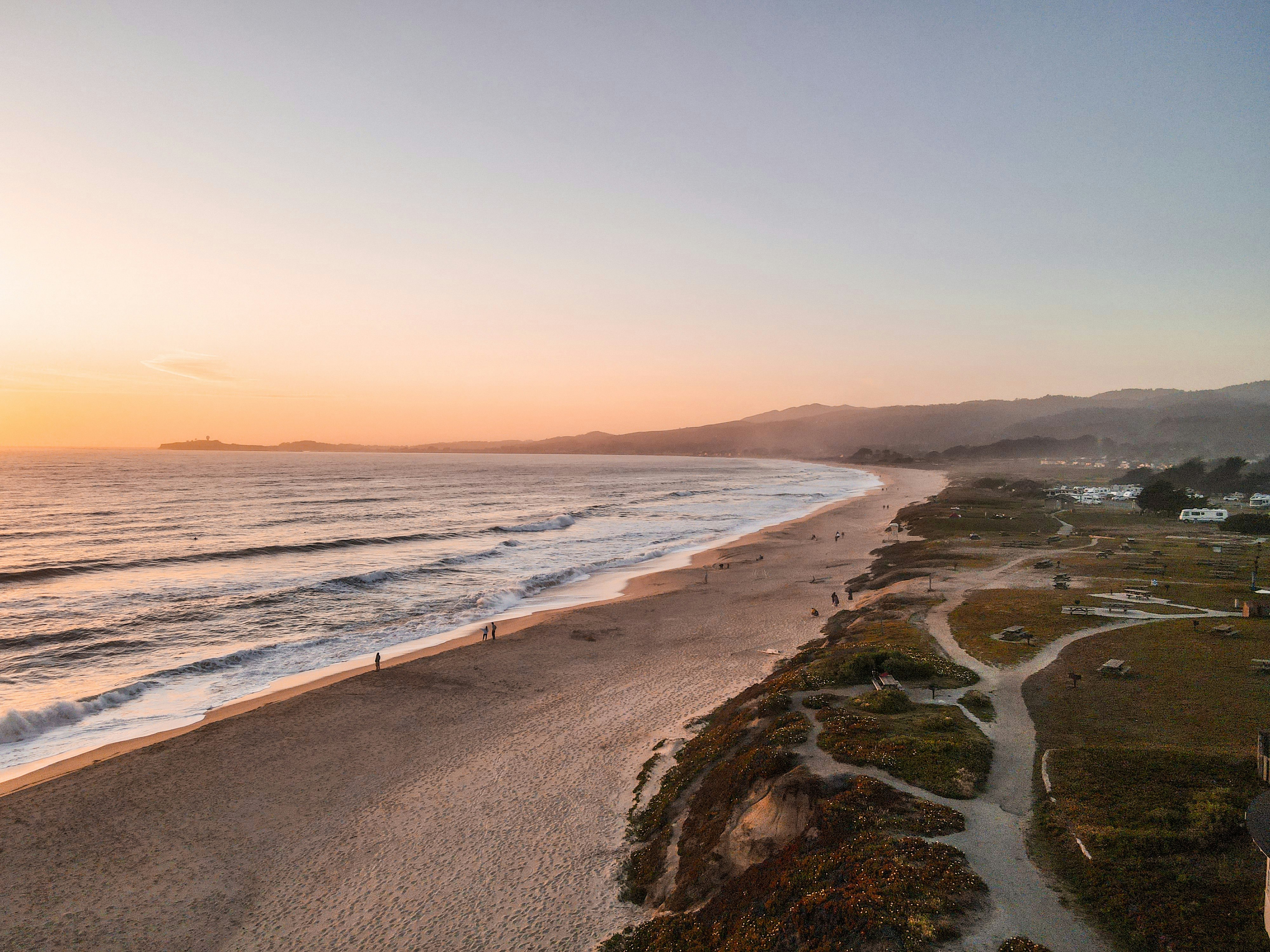 people walking on beach during sunset