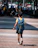 boy in blue and yellow t-shirt walking on sidewalk during daytime