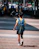 boy in blue and yellow t-shirt walking on sidewalk during daytime