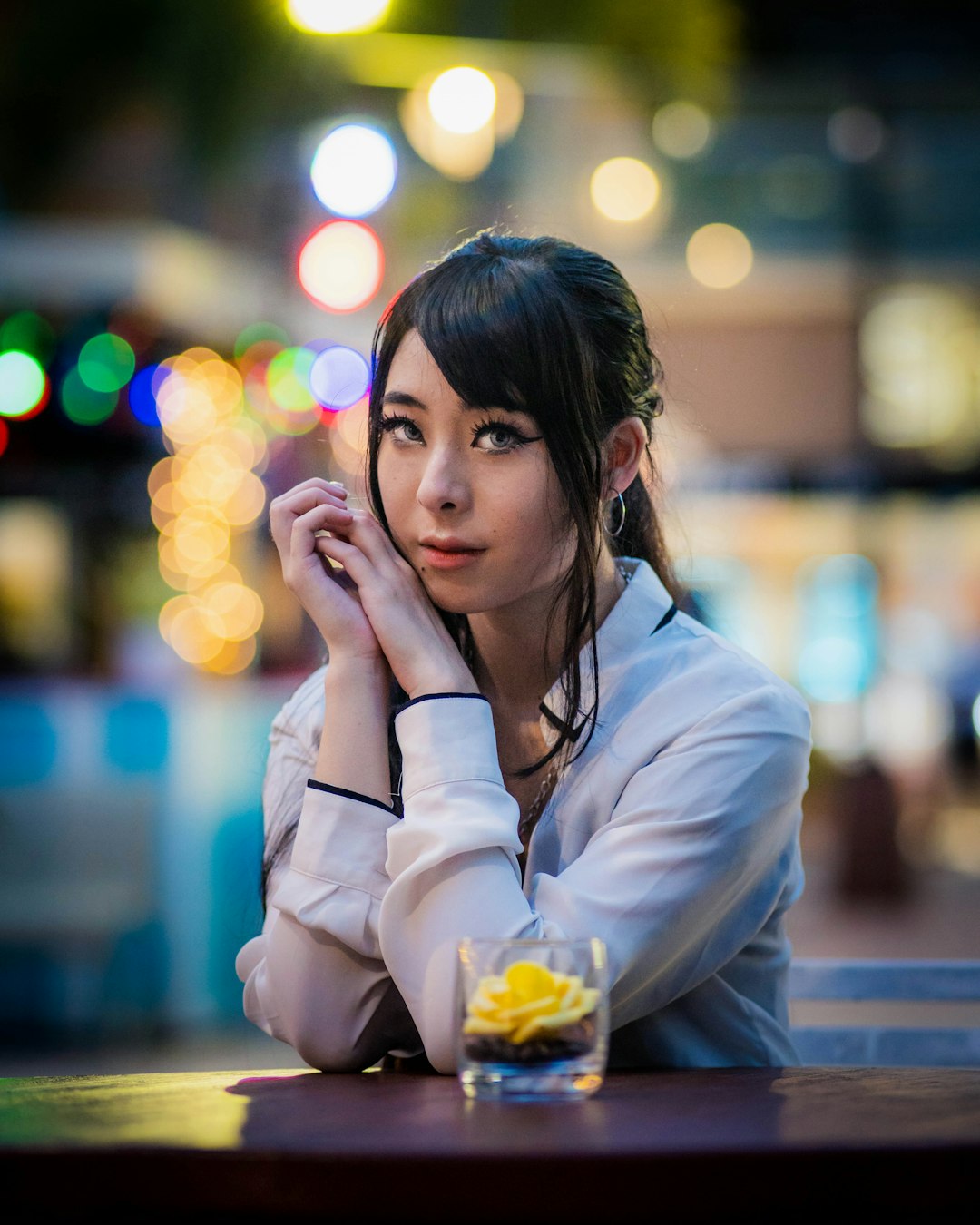 woman in white dress shirt holding her face