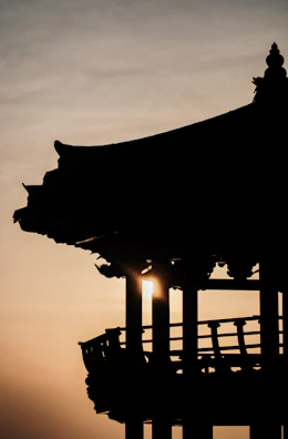 Architectural detail of a monster house’s distinctive roofline against a sunset sky.