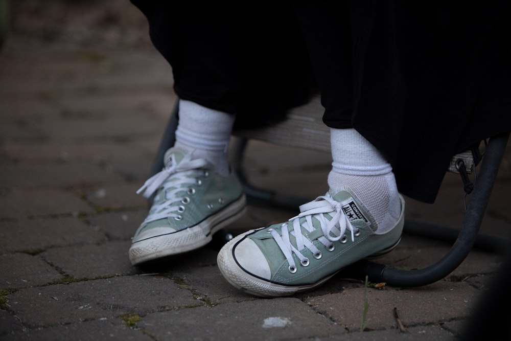 person in black pants wearing white sneakers