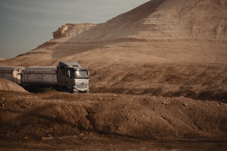 Heavy-duty fuel transport trucks moving along a desert highway.