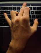 Close-up of hands adjusting settings on a laptop with AI software interface.