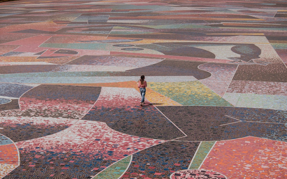 woman in black shirt and black pants walking on red and white concrete floor