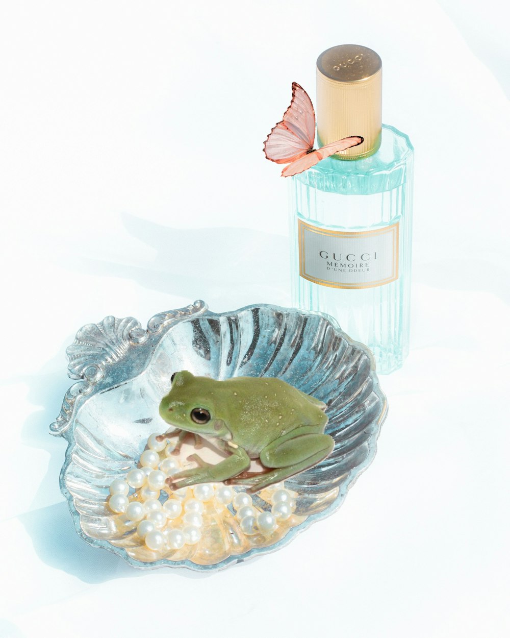 green frog figurine beside pink and white bottle