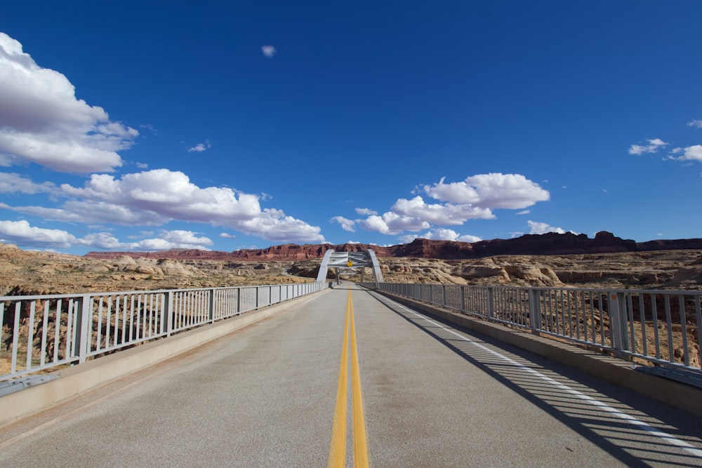 gray concrete road under blue sky during daytime