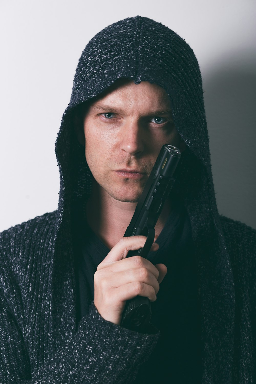 man in black knit cap holding black smartphone