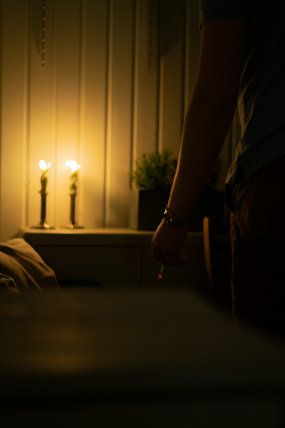 person in white shirt holding lighted candle