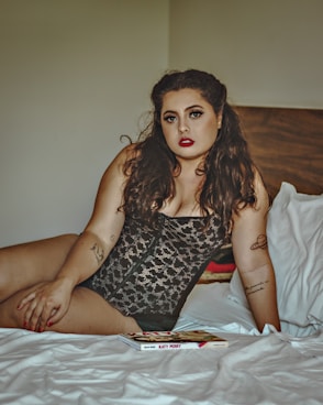 woman in black and white polka dot spaghetti strap dress sitting on bed