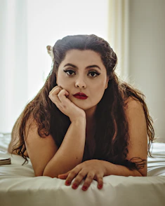 woman in black tank top lying on bed