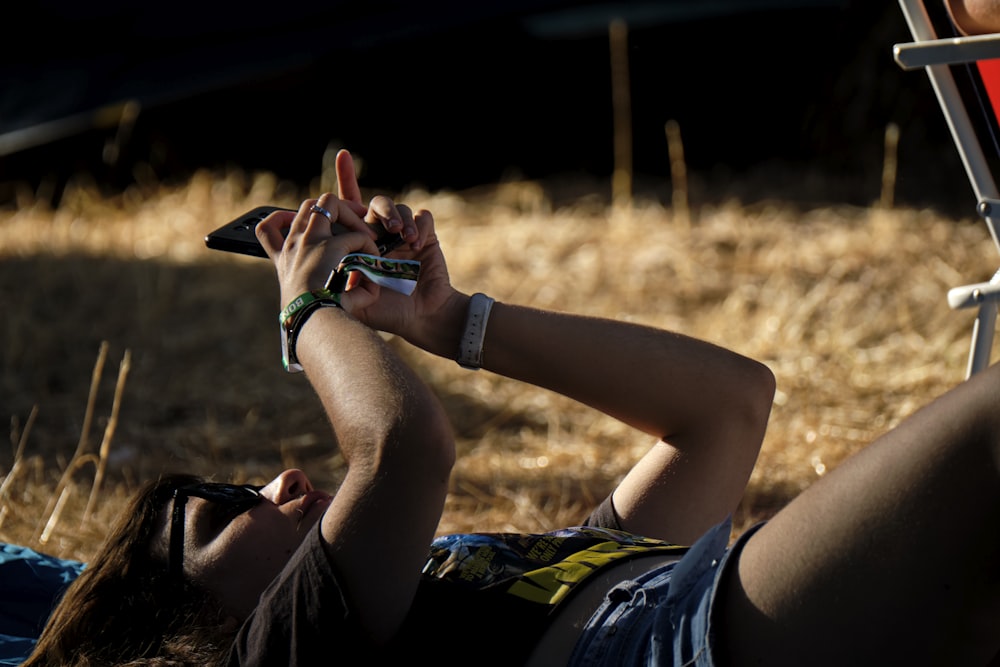 man in black shorts lying on brown grass field during daytime