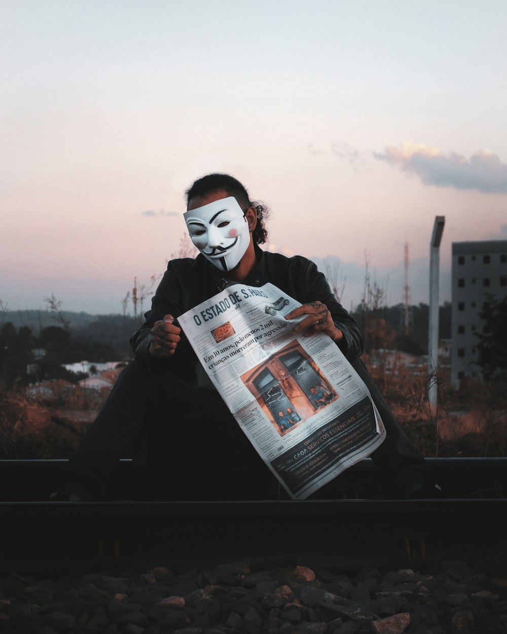 man in black jacket holding newspaper